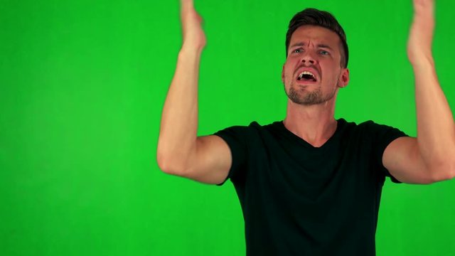 young handsome caucasian man is angry (scold someone) - green screen - studio