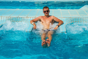 Athletic confident man relaxing in pool jacuzzi outdoor at spa resort enjoying luxury life....