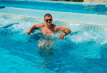 Confident Successful man relaxing in pool jacuzzi outdoor at spa resort enjoying luxury life. Success, healthy lifestyle, body care concept.