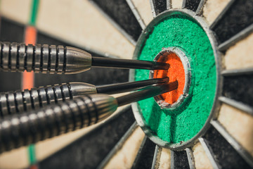 three darts in bull's eye, close up