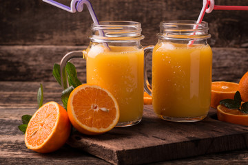 Obraz na płótnie Canvas Citrus juice and fruits on wooden background.