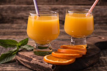 Citrus juice and fruits on wooden background.