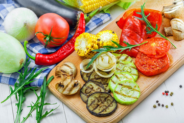 Set of grilled vegetables meal and ingredients: tomato, corn, eggplant, mushroom, bell pepper, marrow and onion. Healthy organic food on a table.