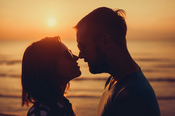silhouette of couple on sunset beach, beautiful background about love and relationships, man and woman
