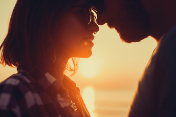 silhouette of couple on sunset beach, beautiful background about love and relationships, man and woman