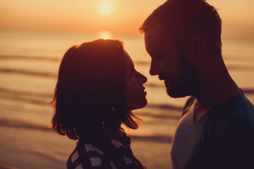 silhouette of couple on sunset beach, beautiful background about love and relationships, man and...