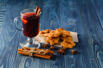 Mulled wine with orange and spices on dark background with copy