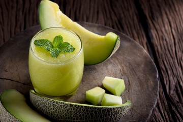 Fresh melon smoothie with almond in a glass on old wooden table background.Selective focus.