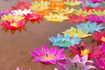 Colorful candle in lotus shape floating on water