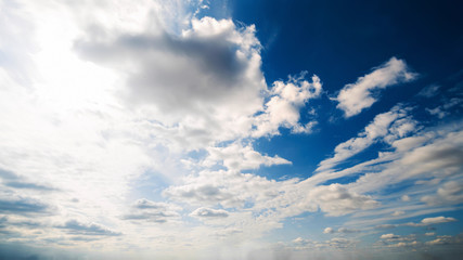 Beautiful summer day sky. Clear crisp cloudscape with large, building clouds, light rays and sun flare, perfect for digital composition background. Wide angle panorama lens