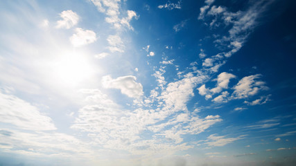 Beautiful summer day sky. Clear crisp cloudscape with large, building clouds, light rays and sun flare, perfect for digital composition background. Wide angle panorama lens