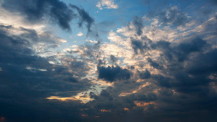 Beautiful autumn evening building clouds with sunset close to night. Clear crisp cloudscape with large, building clouds and light rays, perfect for digital composition background.