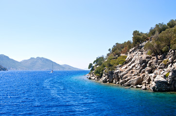 The blue water of the Aegean Sea off the coast of a rocky island