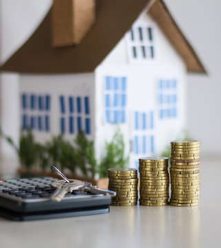 Mortgage concept focused on the coins and keys real estate property with loan money bank concept.