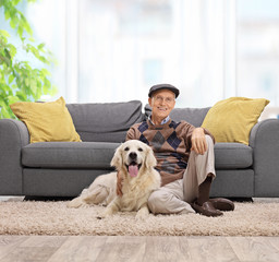 Elderly man sitting on the floor with his dog