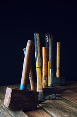 Many old hammers on wooden table