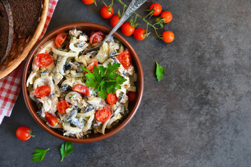 Holiday salad with mushrooms, tomatoes and sauce on a black back