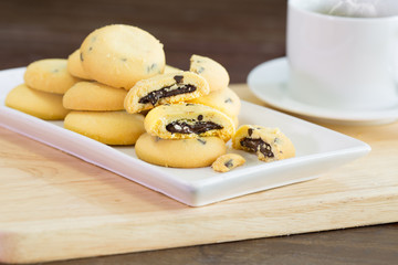 Chocolate lava cookies and coffee on chopping wood in white dish