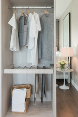 nodern walk in closet interior design with clothes hanging on ra