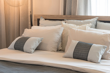 set of pillows on modern bed in bedroom interior