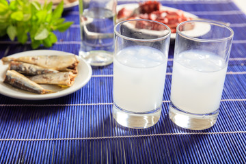 Two glasses of ouzo and appetizers