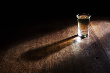 Shot glasses of Brazilian cachaca isolated on rustic wooden background