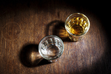 Shot glasses of Brazilian cachaca isolated on rustic wooden background