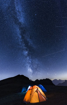 Italy, Dolomites, Milky Way over Monte Pelmo with tents of camp in the foreground