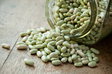 Haricots secs et bocal de verre  sur table en vieux bois