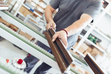 Obraz premium Manual worker assembling PVC doors and windows. Manufacturing jobs. Selective focus. Factory for aluminum and PVC windows and doors production.