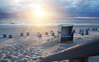 Fototapeta na wymiar Sunset at the sea with beach chairs