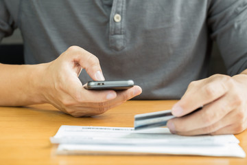 Male hands using calculator apps for calculate credit card bill