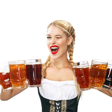 Young sexy Oktoberfest waitress, wearing a traditional Bavarian dress, serving big beer mugs isolated on white background.