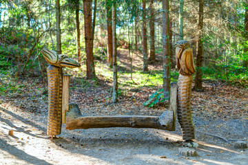 Old wooden sculptures in the forest. Witch Hill park, Lithuania.