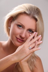 Beautiful young blonde shows off jewelry ring with stone
