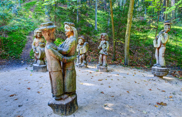 Old wooden sculptures in the forest. Witch Hill park, Lithuania.
