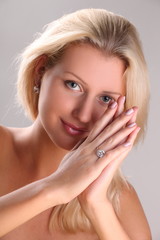 Beautiful young blonde shows off jewelry ring with stone