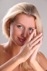 Beautiful young blonde shows off jewelry ring with stone