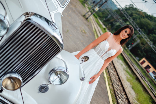 Bride standing by the classic car