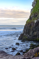 Fototapeta na wymiar Stone wall ending in the sea where it meets the sea and the waves