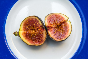 ripe fig sliced in half on a blue and white plate