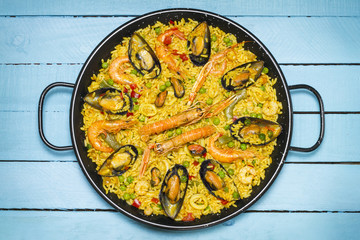 Spanish paella on a wooden table.