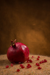 Pomegranate slices and garnet fruit seeds on table.