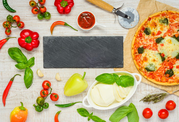 Pizza with Ingredients and Copy Space on a Dark Plate