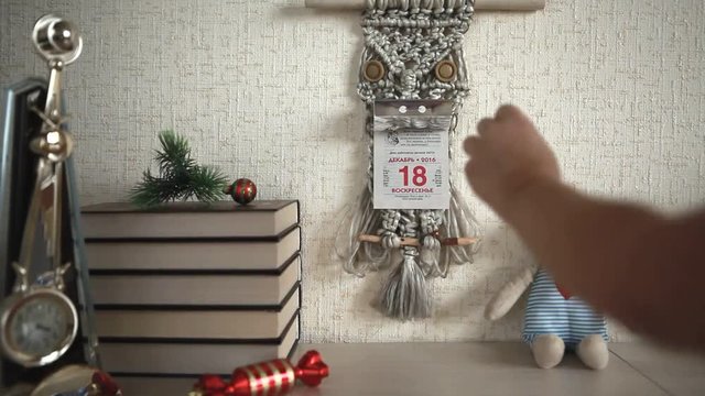 The child tears off a sheet with the date of 18 December 2016 wall calendar