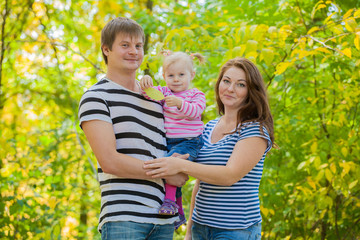 happy family in the same clothes for a walk in the park in autumn