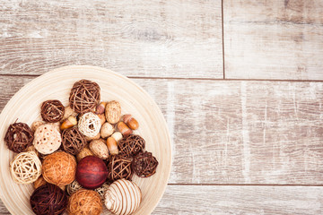 Autumn plate with oak acorns, wicker balls on wooden background. Copy space at right. 