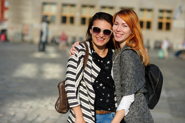 Two young women stand having embraced.