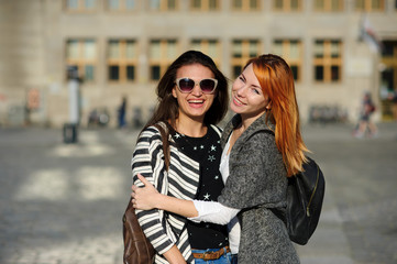 Two young women stand having embraced.