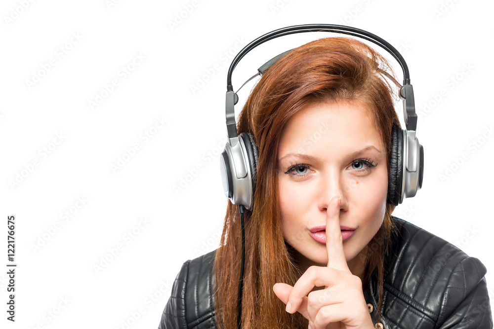 Wall mural girl in headphones asks keep quiet on a white background isolate